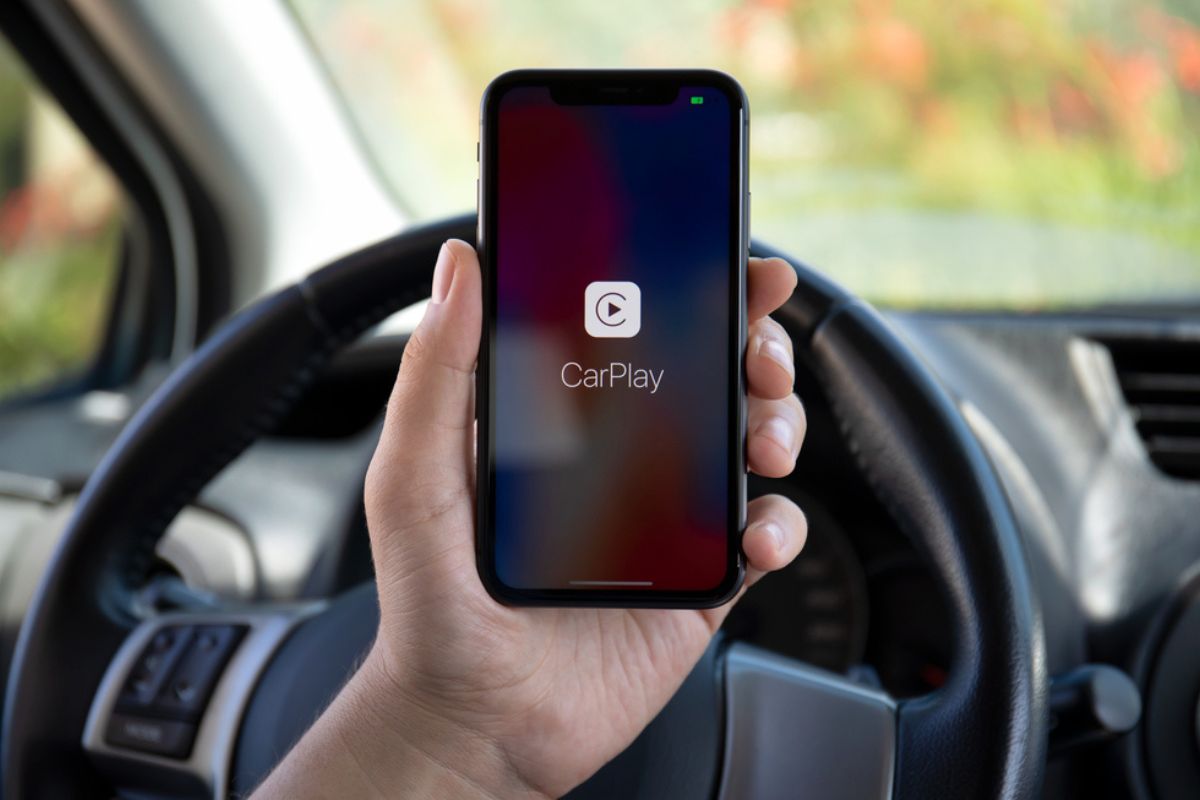 Woman hands holding Apple iPhone 11 with CarPlay in the screen phone Toyota car.