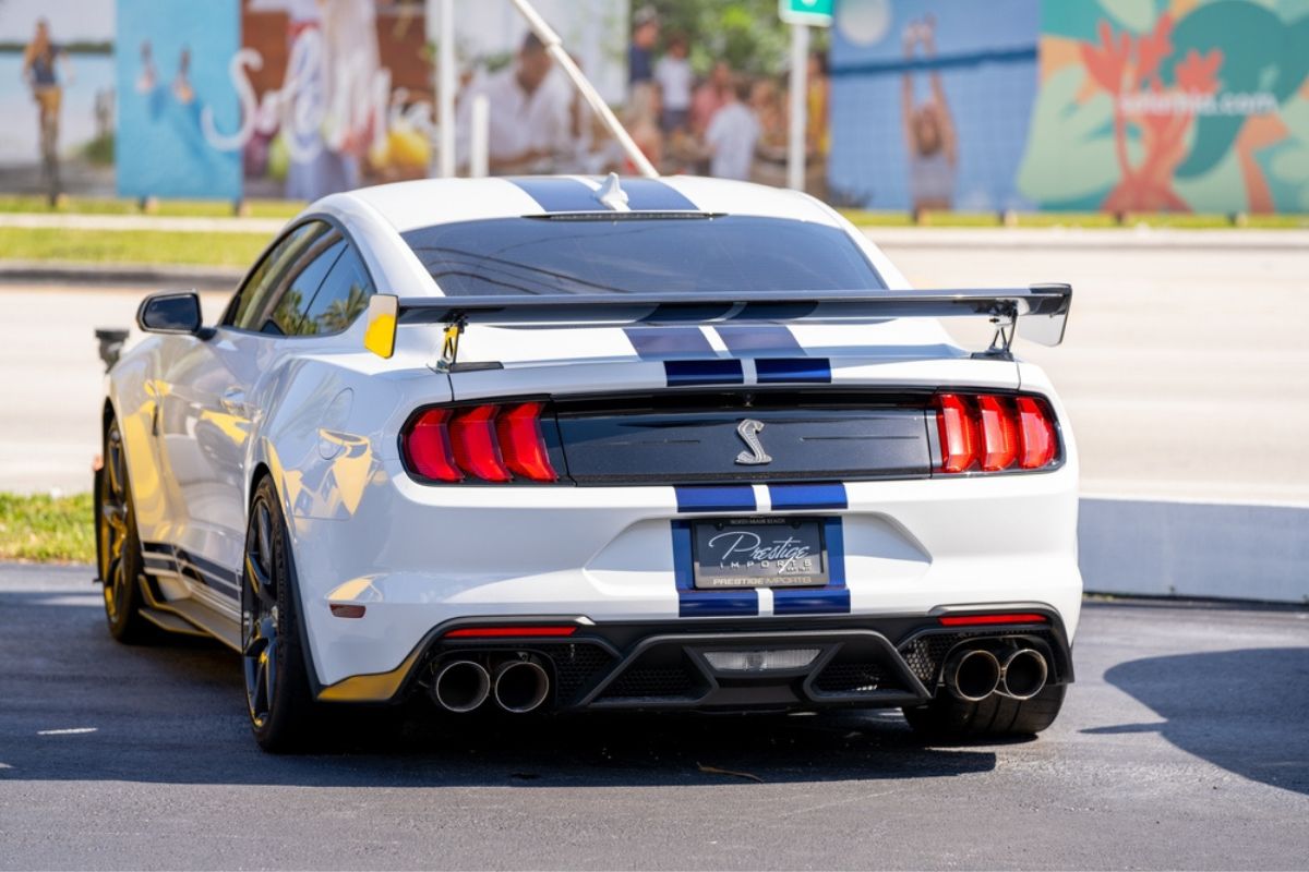 Photo of a white Ford Cobra GT 500 with blue stripes.