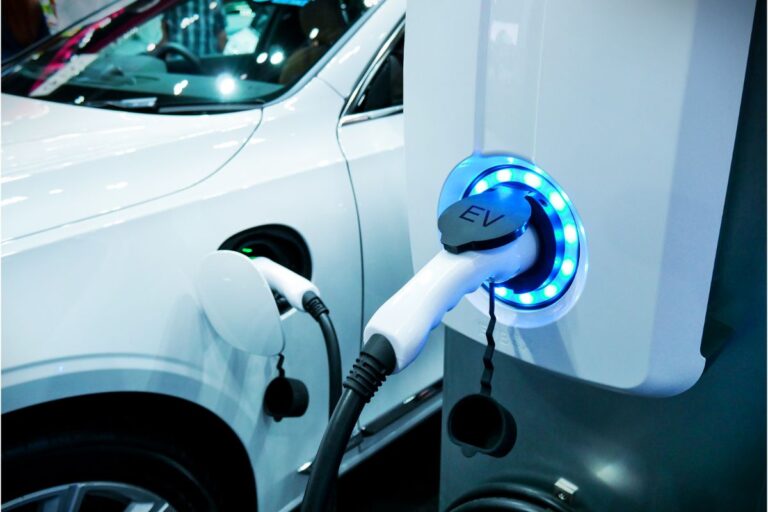 A white electric vehicle charging into the power supply.