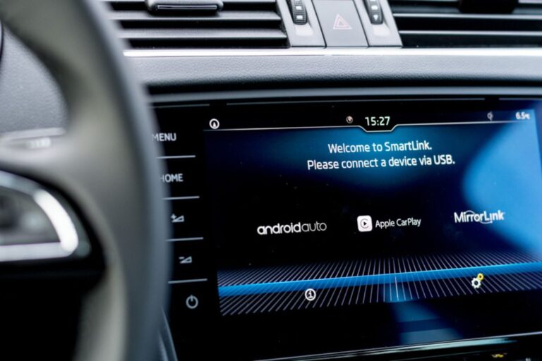 On board computer in a modern car displaying available phone connection services like Android Auto and Apple CarPlay.