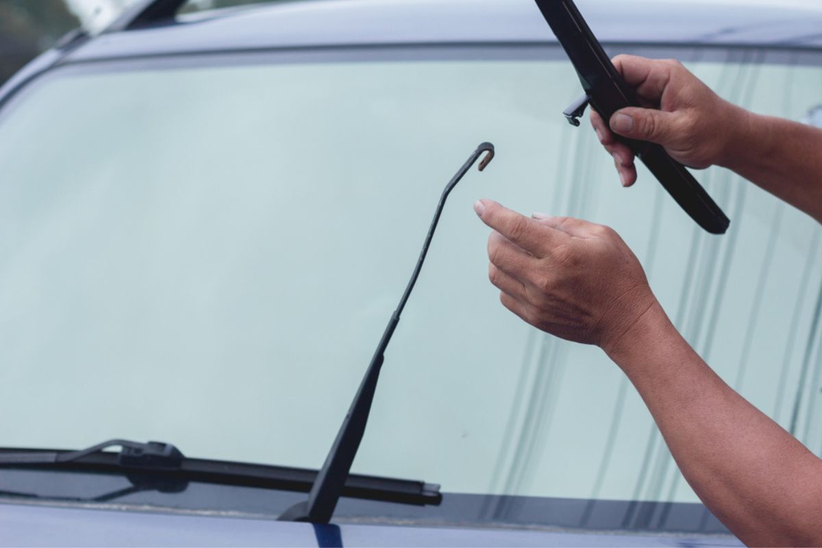 Mechanic replace windshield wipers on car. Replacing wiper blades Change cars wiper blades.