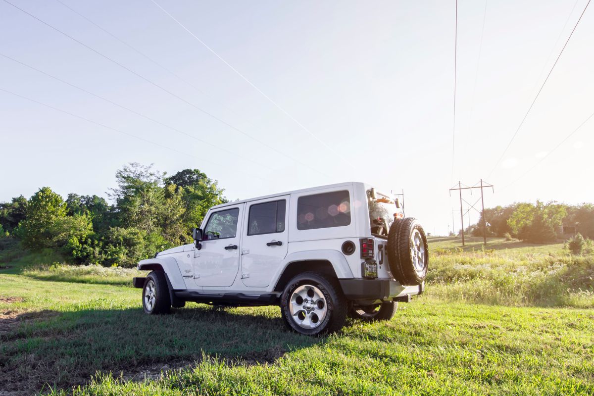 White jeep wrangler on the green grass.