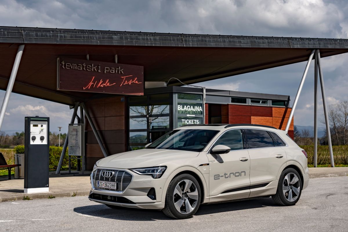 At the entrance to the Nikola Tesla Mausoleum in Smiljani, an Audi e-tron is parked next to an electric charger.