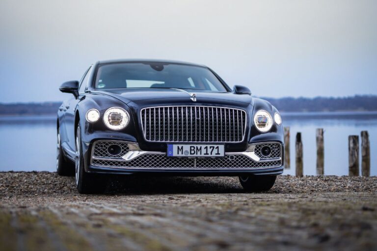 Front view of Bentley Flying Spur with a lake background.