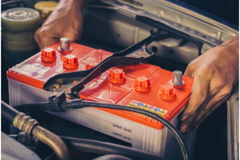 A battery is changed by a mechanic.