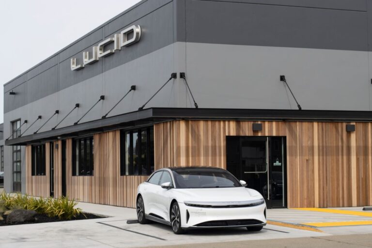 Outside a Lucid showroom, a pre-production electric Lucid Air is visible.