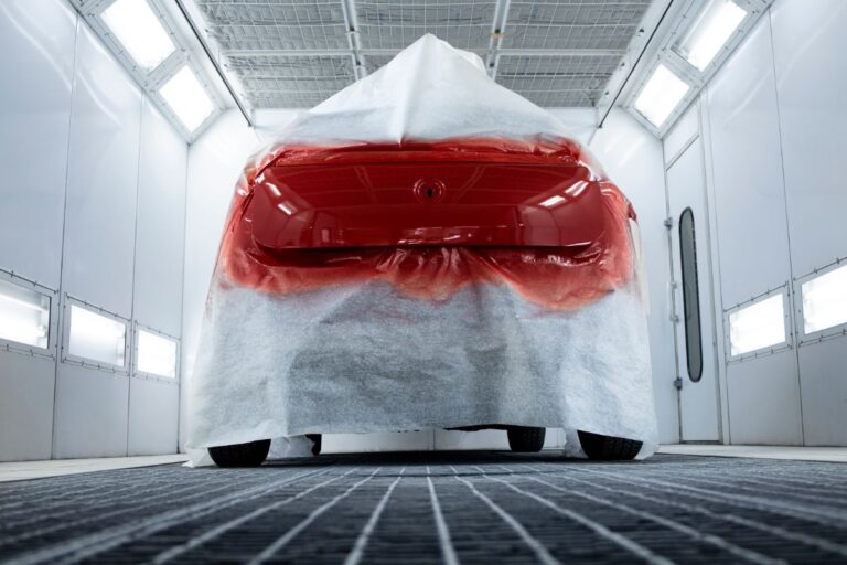 A car painted in red being dried up in a car painting store.