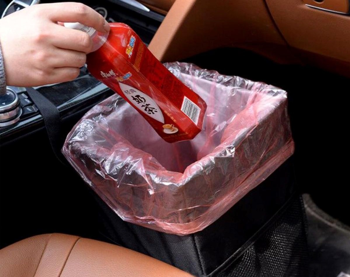 Car driver putting trash on car.