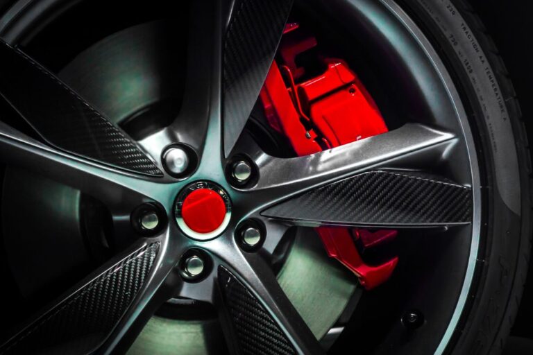 A close-up of a gorgeous, pricey supercar's painted, large alloy wheel.