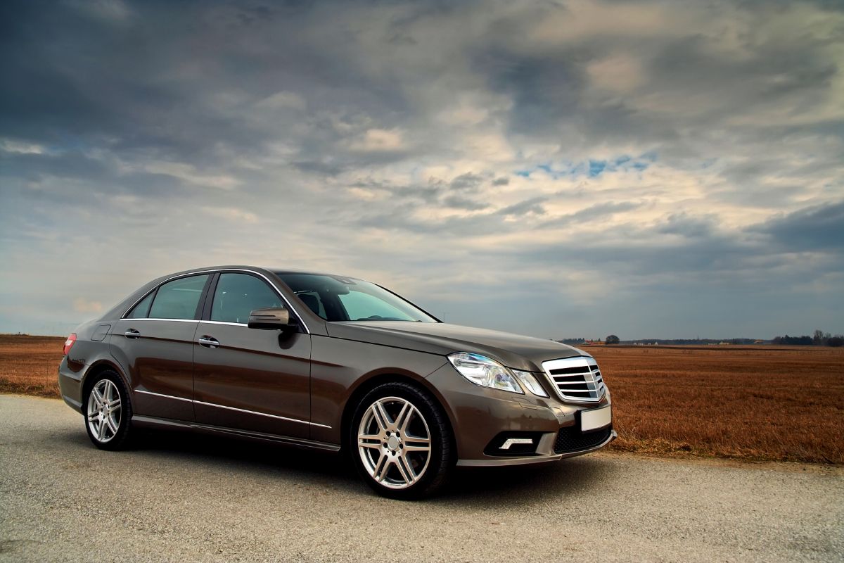 Side view shot of a luxury car, driving on the road.