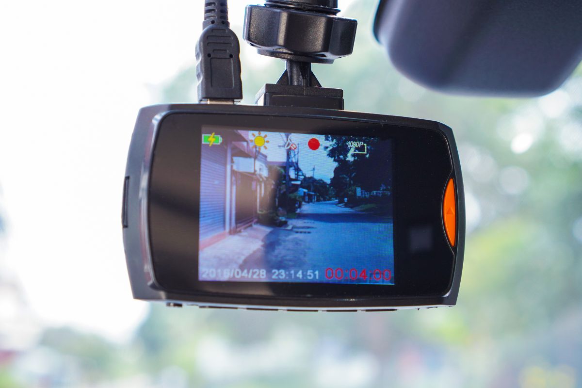 A dash cam on car capturing video on road.