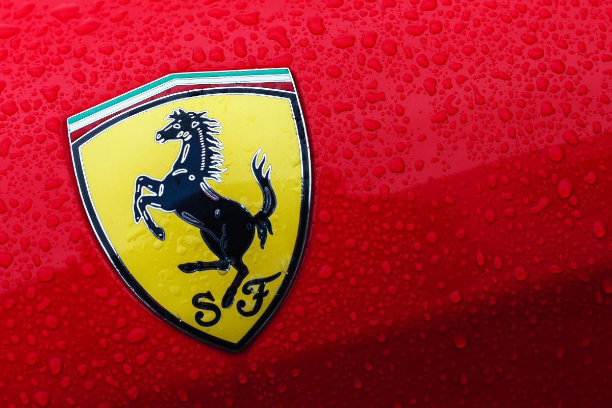 Close up photo of a wet Ferrari logo in a Ferrari sportscar.