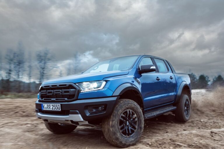 On sand and dirt, a Ford Ranger Raptor T6 mid-size pickup vehicle is seen drifting.