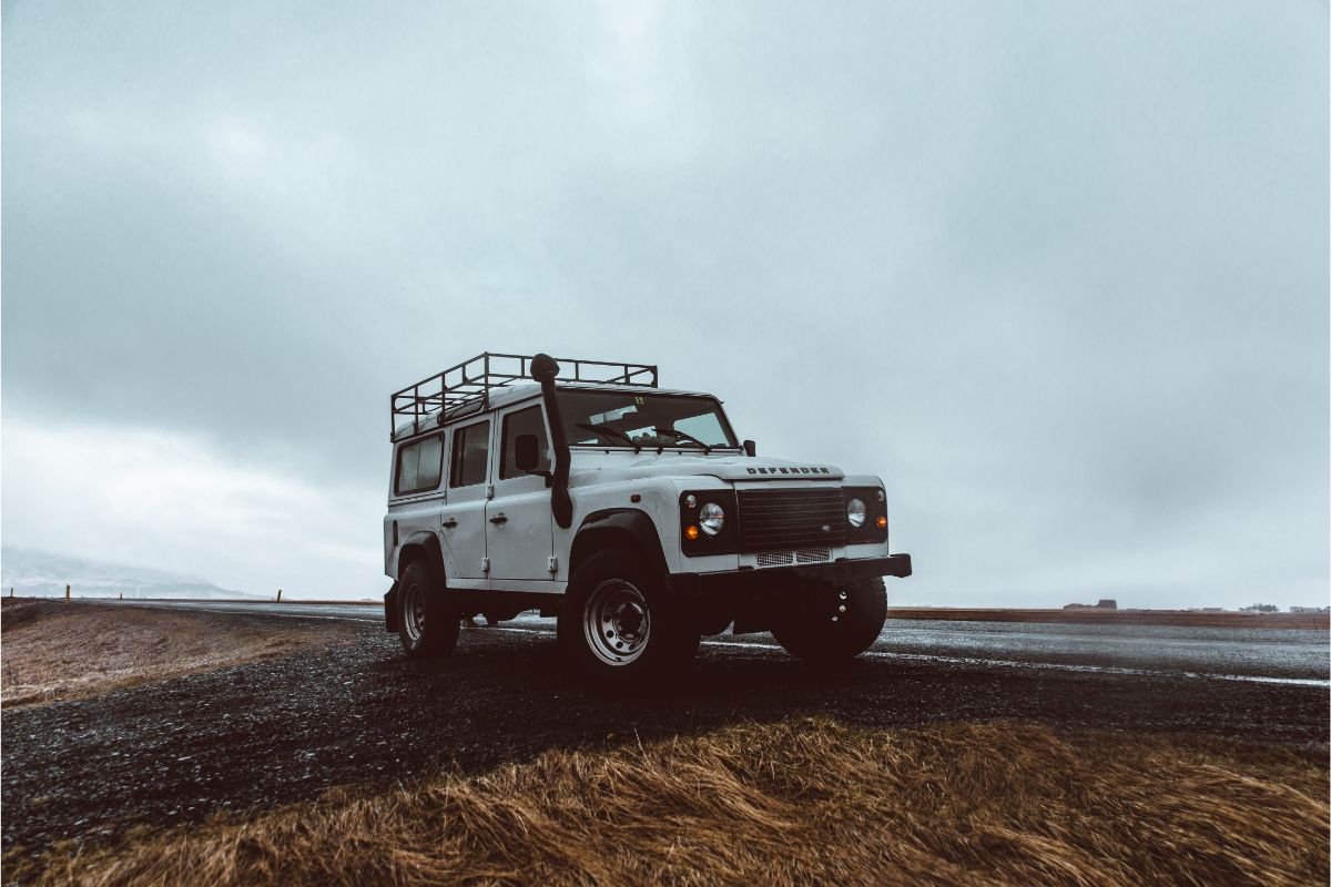 A wide angle photo of white jeep on the road.