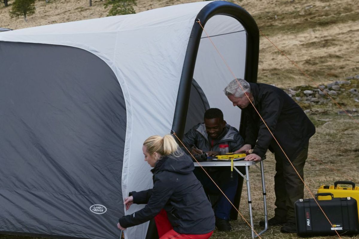 A photo of three people making their Inflatable Waterproof Awning.