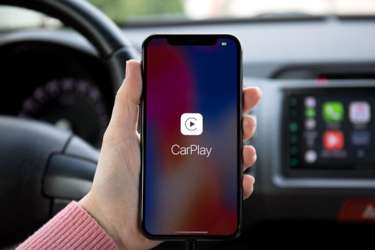 A man holding an IOS device and opened apple car play.