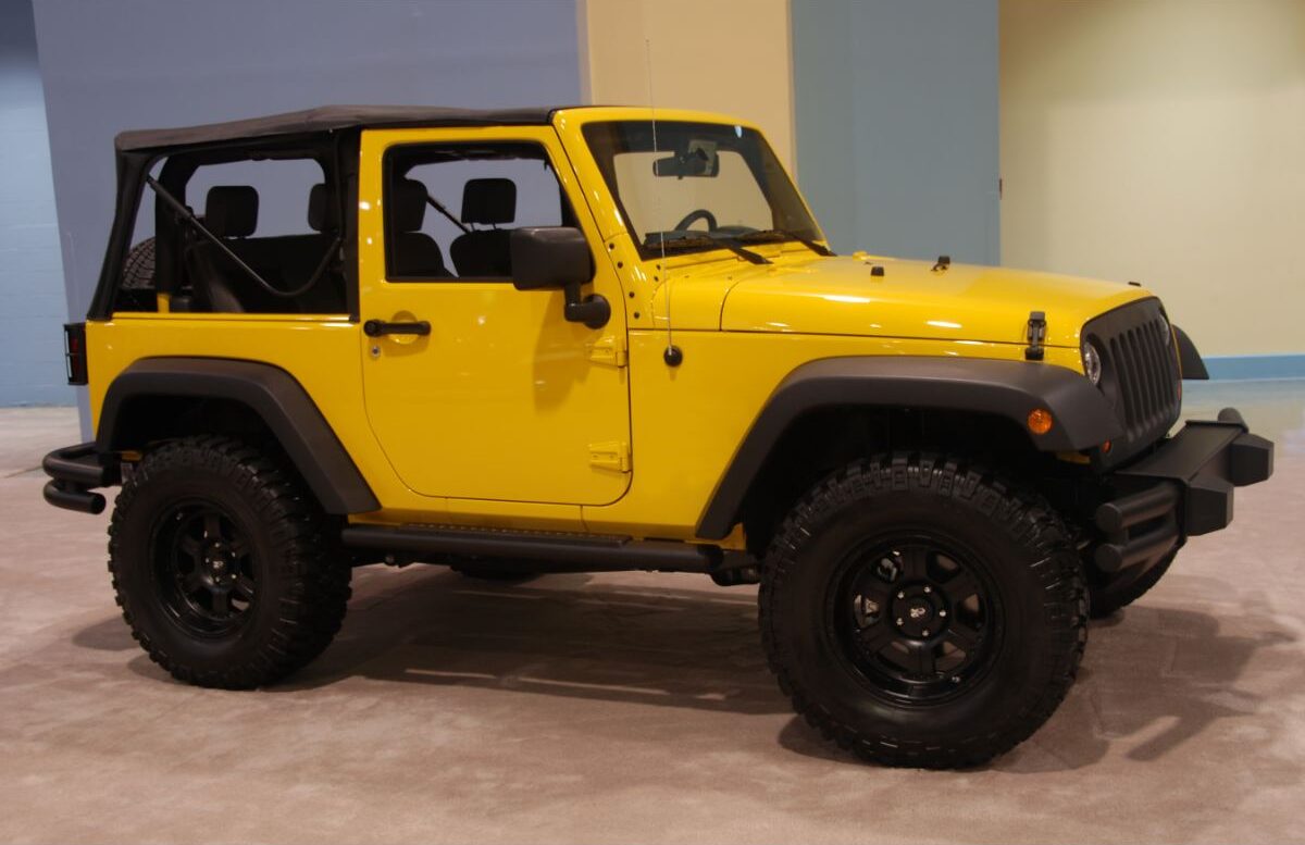 Side view shot of yellow jeep displayed at the dealership.