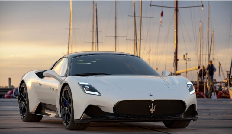 Fron view of a luxury white Maserati MC20 parked at sunset.