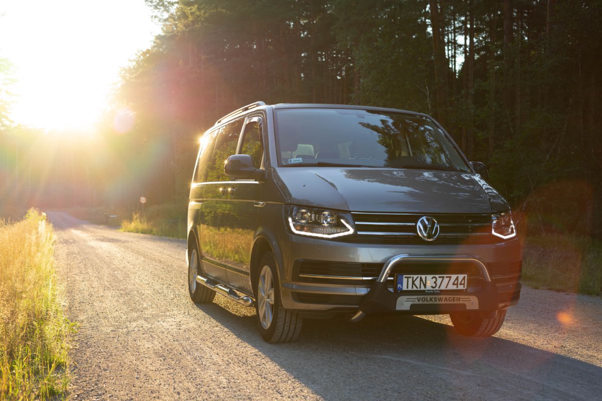 Front shot of minivan driving in the road with sunset view.