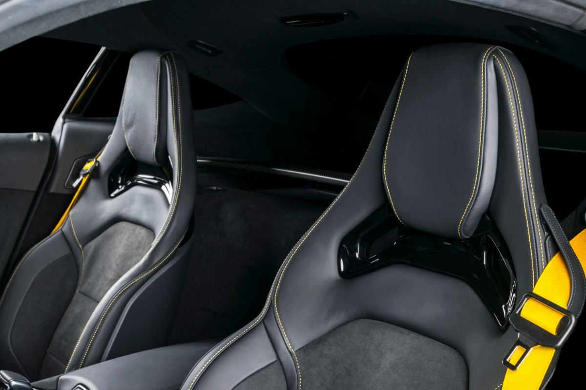 Luxurious modern automobile interior with plush leather seats and yellow stitching.