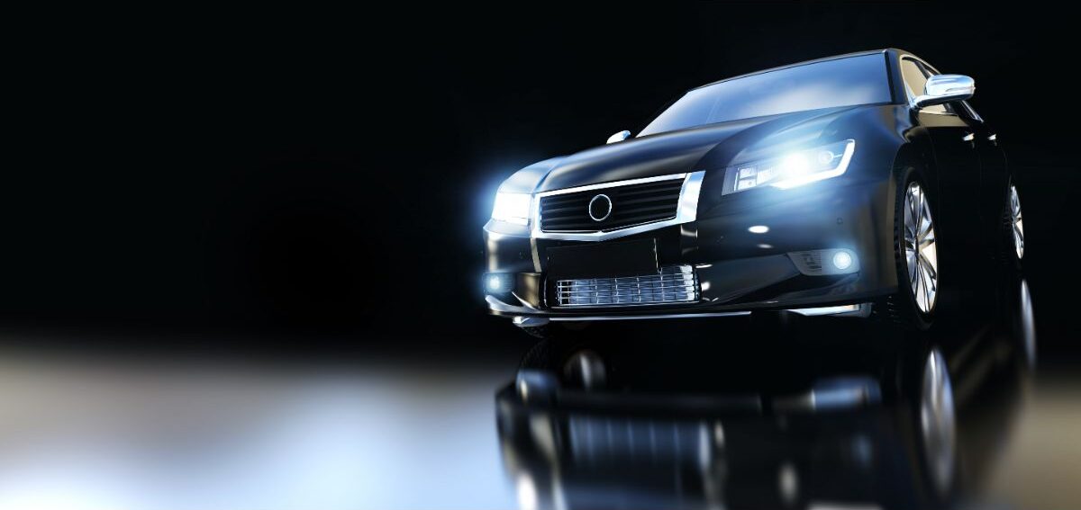 Front view of a modern black metallic sedan car with a floor reflection.