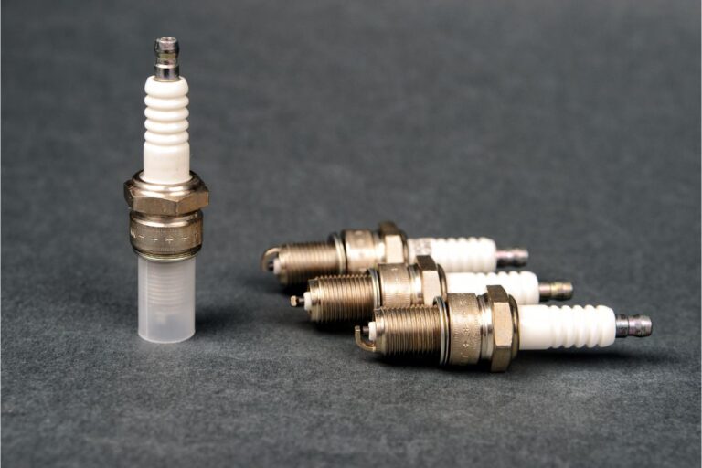 Close up photo of four spark plug laying on the ground.