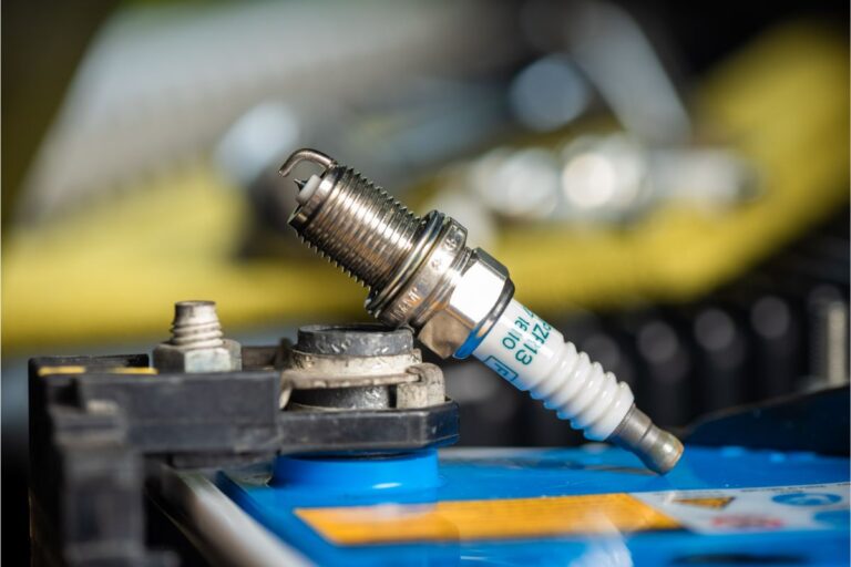 Close-up of a brand-new car spark plug in the engine bay.