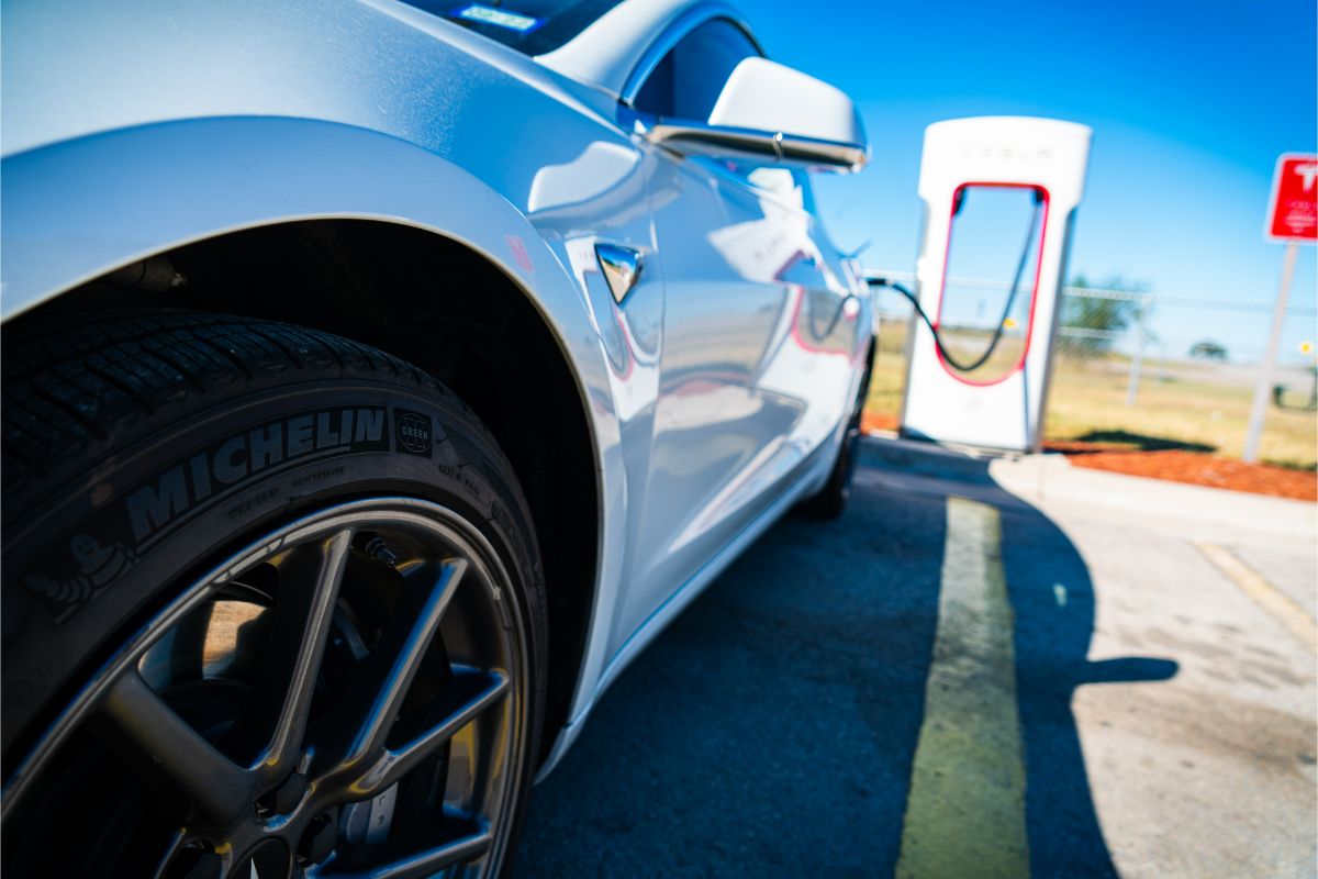 Single side image of a white Tesla charging at the charging station.