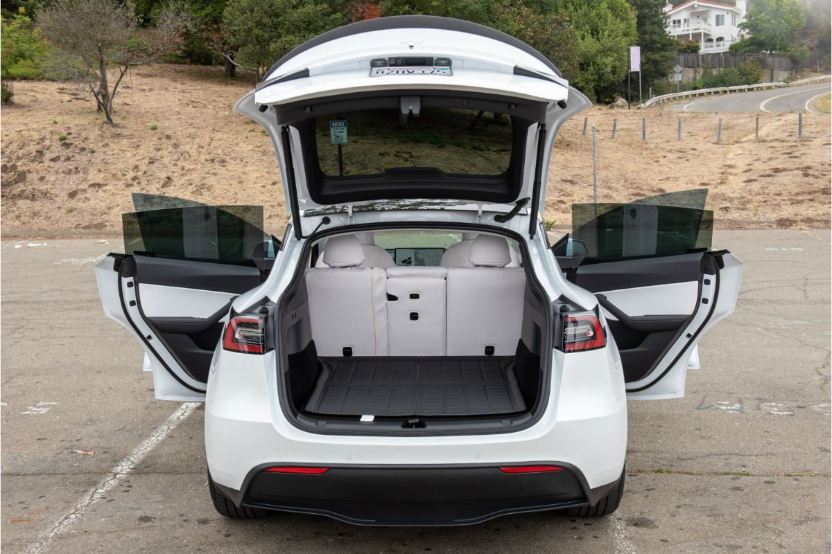 Back view of a white Tesla Model Y with its trunk open.