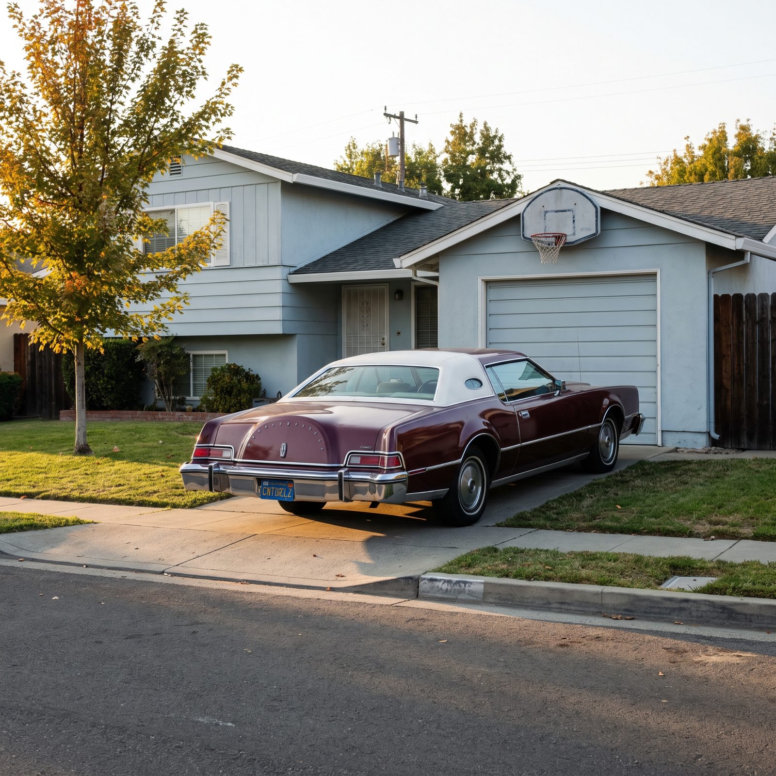 Long maroon 1974 Lincoln coupe in a short driveway with its rear bumper overhanging the sidewalk, in front of a split-level