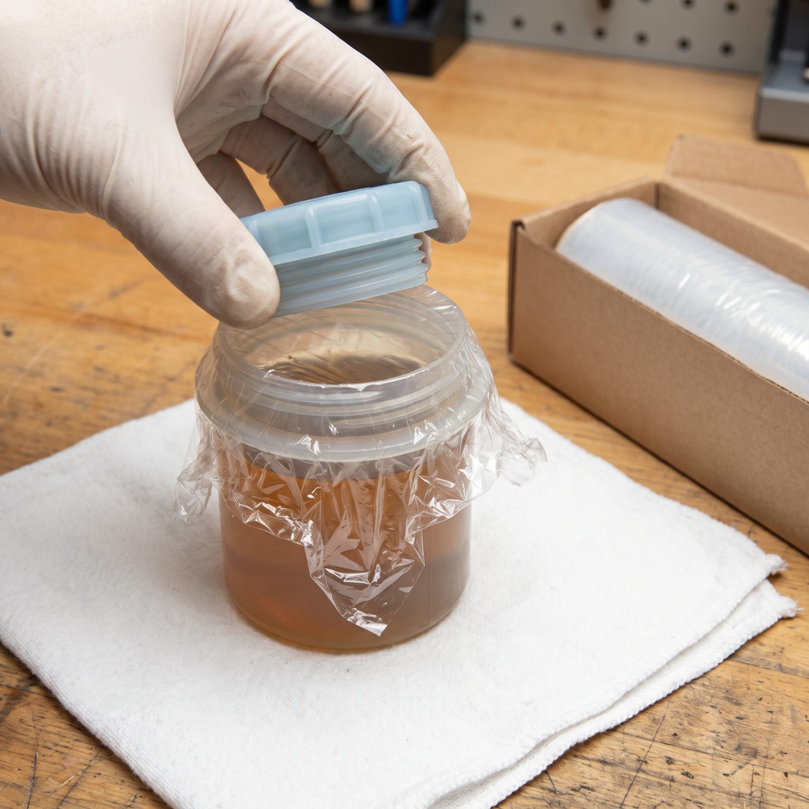 Slip Plastic Wrap Beneath a Fluid-Reservoir Cap to Slow Drainage