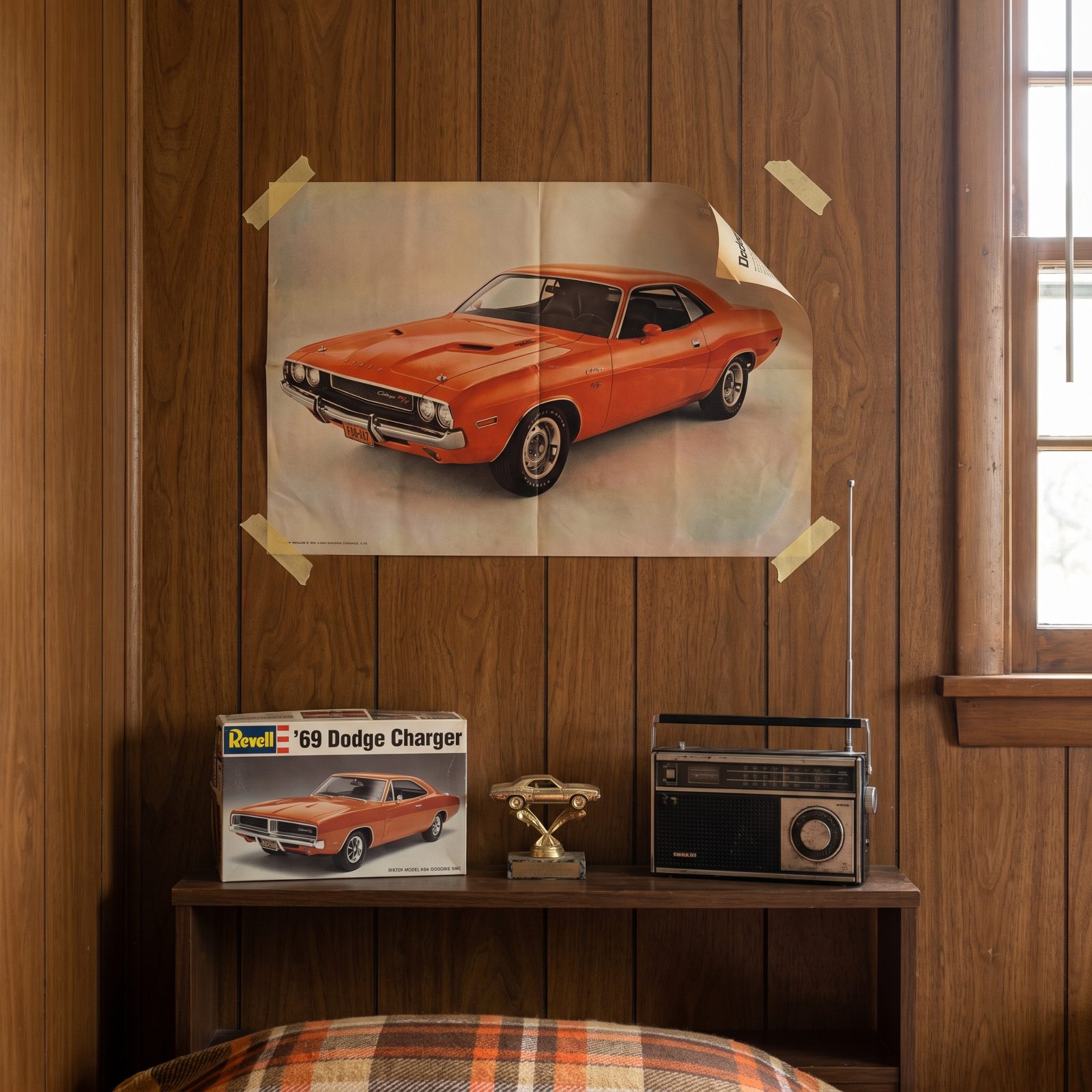 Wood-paneled bedroom wall with a magazine photo of an orange fastback taped up at the corners, one corner curling.